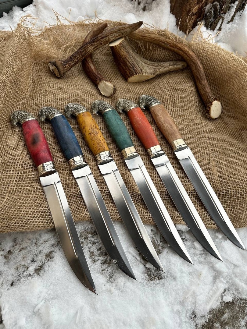 Пластунский нож — это не просто длинный клинок. Это символ боевого ножа, сделанного для дела, а не для витрины. Это серьёзное оружие, с определённой философией и прямым предназначением: работать в самых жёстких условиях, когда нет права на ошибку. Я — Максим Заботин, основатель компании «Ножи Заботин», и сегодня расскажу, как мы подходим к созданию пластунских ножей, почему это не просто увеличенная финка и чем наши модели отличаются от дешёвых копий и музейных реплик.
Начну с истории. Пластун — это разведчик, казак, боец, который действует вне колонны, без прикрытия, в тылу. Такой человек не имел права на ненадёжный нож. Ему нужен был клинок, который и прорежет, и пробьёт, и выстоит. Именно под эти задачи и формировался пластунский нож — массивный, тяжёлый, с длинным клинком, сбалансированной рукоятью и высокой проникающей способностью. И это важно: этот нож делается не для полки, а для настоящей мужской работы.
Когда ко мне приходят с просьбой сделать пластунский нож, я сразу предупреждаю: это будет серьёзный инструмент. Не сувенир. Не стилизация. Настоящий. Именно так мы и делаем в нашей кузнице — от первой поковки до последнего полировочного движения. Каждый этап проходит через руки специалистов: кузнецов, шлифовщиков, сборщиков, мастеров по дереву и ножнам.
Пластунский нож — это, в первую очередь, клинок. Мы делаем его массивным: с толстыми обухами, мощным сведением и чёткой, симметричной геометрией. Сталь — только надёжная. В зависимости от задачи, я использую:
— D2 — рабочая инструменталка, которая держит рез и не боится нагрузки.— M390 — нержавеющая сталь с отличным удержанием кромки и высокой стойкостью к износу.— Булат — для особых задач, когда важна не только мощь, но и характер. Его мы варим сами, травим вручную и доводим до состояния боевого зверя.— Дамасскую сталь — многослойный, агрессивный, плотный клинок, сделанный по моей формуле из ХВГ, ШХ-15, У8А и стали 40.
Каждый клинок тестируется на пробивную способность, устойчивость к сколам, рез по плотным