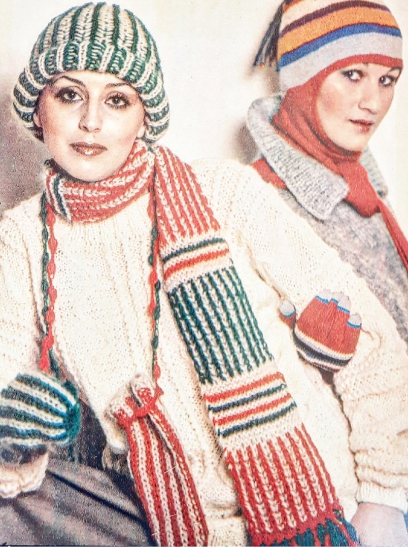 Для образца узора наберите нечет.кол-во петель: 1р.  (лиц.сторона работы-темная нить)- 1лиц,1Н.,1снять и т.д. 2р.(изн.сторона светлая нить)- 1Н.,1снять,1лиц(провязывая накид с петлей,считая их за одну) и т.д. 3р.(изн.сторона,вязанье передвинуть к противоположному концу спицы и вязать темной нитью)- 1изн.(вязать накид с петлей),1Н.,1снять и т.д. 4р.(лиц.сторона-светлая нить)- 1Н, 1снять,1изн.(накид с петлей) и т.д. 5р.(лиц.сторона,вязанье передвинуть к противоположному концу спицы и вязать темной нитью)-1лиц(накид с с петлей),1Н., 1снять и т.д. 6р повторять со 2 ряда. Для ШАПОЧКИ наберите 47п (55-56см) и свяжите прямоугольное полотно высотой 30см. Петли последнего ряда нанижите на нить, туго стяните и этой же нитью сшейте шапочку(при рыхлой вязке на макушке лишних сборок не получиться). Нижнюю часть шапочки заверните несколько раз, чтобы образовался валик. Шерсти: ДЛЯ ШАРФА по 35г зеленой и красной, белого мохера 30г. Спицы 6(вязать не туго). Узор вязанья  что и на шапочке. Горизонтальные цветные полосы выполнены платочной вязкой(все ряды -лиц.п.). Ширина каждой полосы- 2 ряда. Ширина шарфа 13см(19п). длина -165см. Шерсти: ДЛЯ ВАРЕЖЕК по 15г зеленой и красной, 20г белого мохера. Наберите на спицы 21п.и свяжите прямоугольное полотно высотой 27см. Петли последнего ряда нанижите на нитку, туго стяните и сшейте полотно, оставив отверстие для большого пальца.По краю отверстия наберите чулочными спицами 18п.и свяжите палец чулочной вязкой. Декоративная тесьма на варежках и бахрома шарфа выполнены пышными столбиками, крючком 5. Свяжите 3 возд.п., затем свяжите пышный столбик на одной петле, считая от крючка. И так повторяйте, пока не свяжите те ьму необходимой длины. Связав зеленую и красную тесьму( длина каждой 120см), прикрепите ее к варежкам. Доя концов шарфа свяжите сначала красную тесьму, одновременно прикрепляя ее к шарфу через равные интервалы, а затем зеленую, обвивая красную и закрепляя ее.