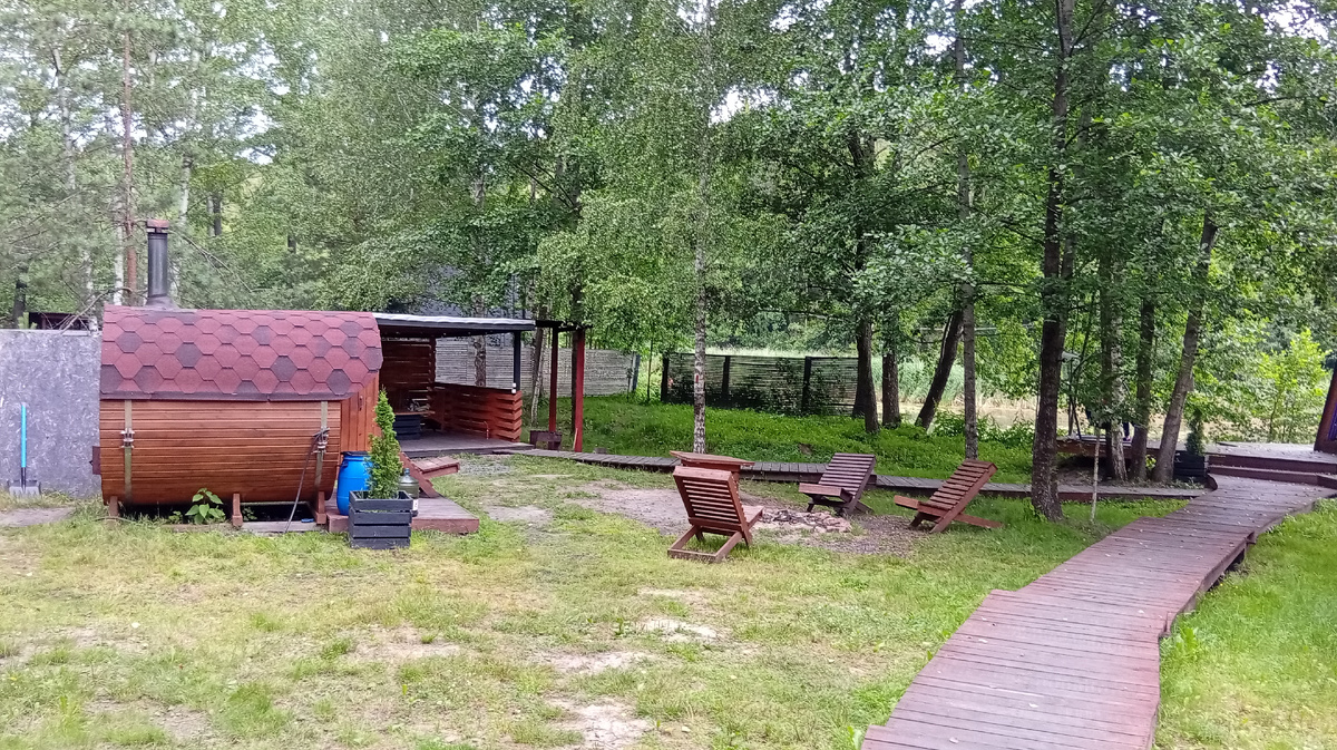 Фиолетовый домик в комплексе Di.Land, июль 2025. Вид от калитки на баню, мангальную зону и беседку. Фото из личного архива автора.