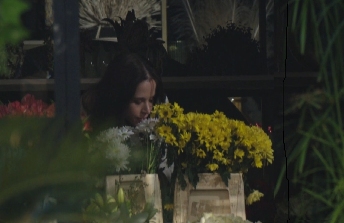 Серап нюхает цветы. На её лице полуулыбка лёгкого приятного удовольствия.