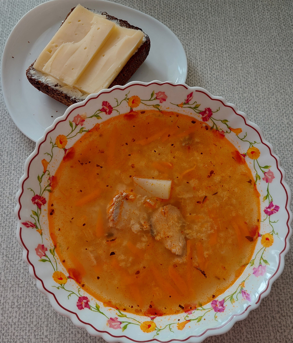 В кастрюлю с кипящей водой бросила картошку, промытое пшено. Как сварилось, добавила консерву горбуши и зажарку из лука, моркови и томатной пасты. Суп ела с бутербродом из черного хлеба, масла и сыра.