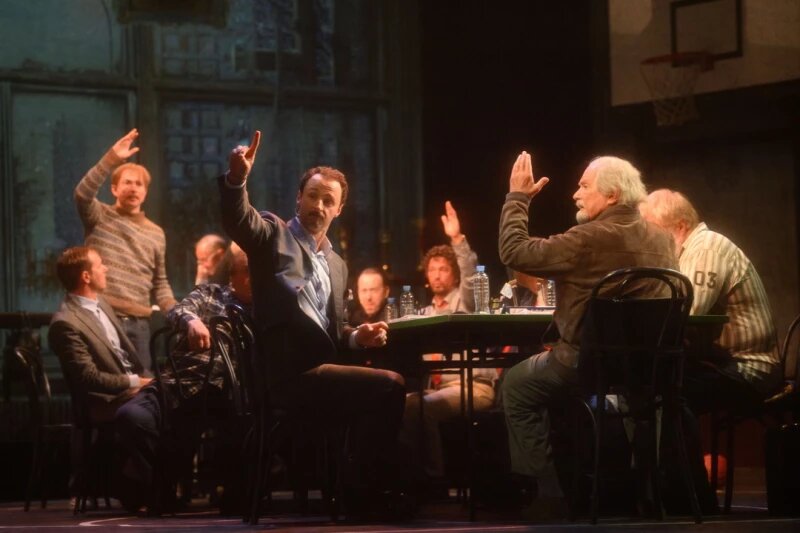 Посмотреть фотогалерею на сайте.   
  17 изображений 18 июля в Барнауле в 101-й раз показали «12» — драму, который Никита Михалков ставил трижды. Сначала по пьесе «12 разгневанных мужчин» американского драматурга Реджинальда Роуза на третьем курсе «Щуки». В 2007-м снял картину, переработав историю в киносценарий. В 2020-м он стал основой инсценировки уже для театральной версии.Сюжет умещается в паре предложений: двенадцать присяжным в спешке собираются решить судьбу чеченского юноши, которого обвиняют в убийстве приемного отца – русского офицера. Единогласного «виновен» не получается – лишь один человек смог отрезвить равнодушных и развернуть мысленное расследование.📷
📷
📷
📷
📷
📷
📷
📷
📷
📷
