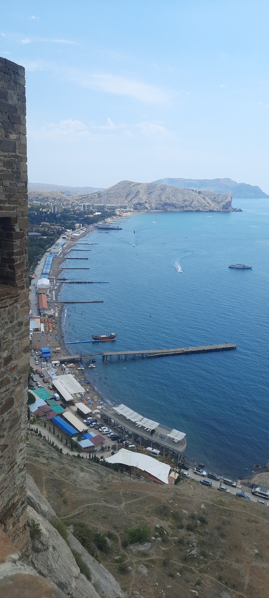 Судак уютно расположен в бухте между горой Крепостной и мысом Алчак, что виден вдали на фото.