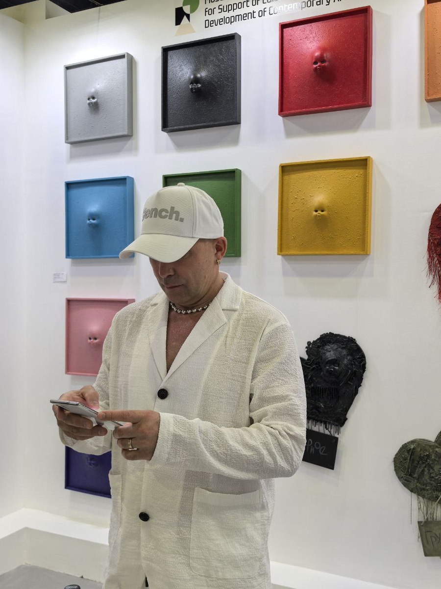 Владислав Аксёнов у своего стенда с работами на World Art Dubai 2025