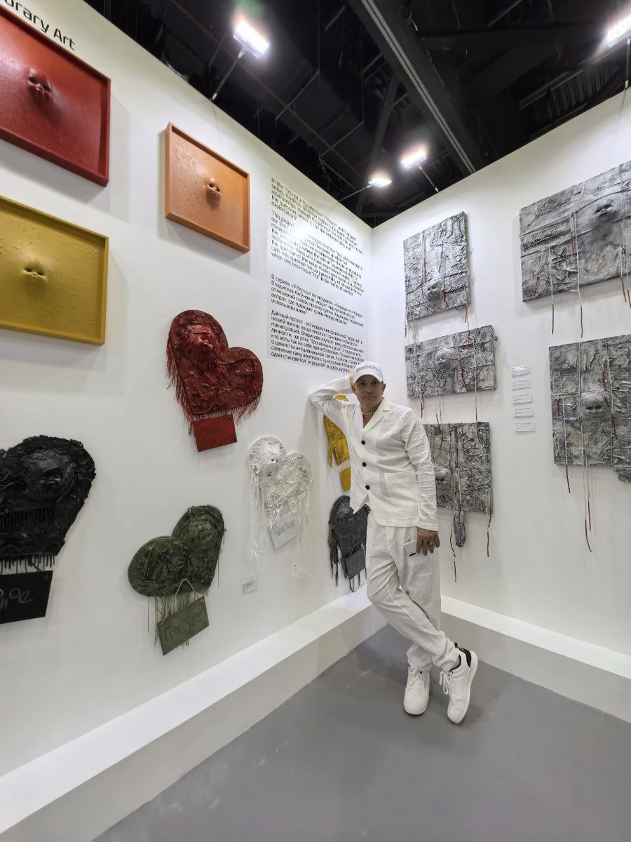 Владислав Аксёнов у своего стенда с работами на World Art Dubai 2025