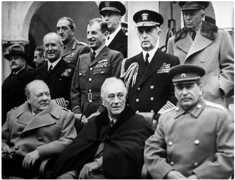 Ялтинская (Крымская) конференция союзных держав (4 -11 февраля 1945 года). В первом ряду (сидят): премьер-министр Великобритании Уинстон Черчилль, президент США Франклин Делано Рузвельт и председатель Совета министров СССР Иосиф Сталин (слева направо) перед началом одного из заседаний. Стоят: министр иностранных дел Великобритании Энтони Иден, государственный секретарь США Эдвард Стеттиниус, американский военачальник Омар Нельсон Брэдли, народный комиссар иностранных дел СССР Вячеслав Молотов.