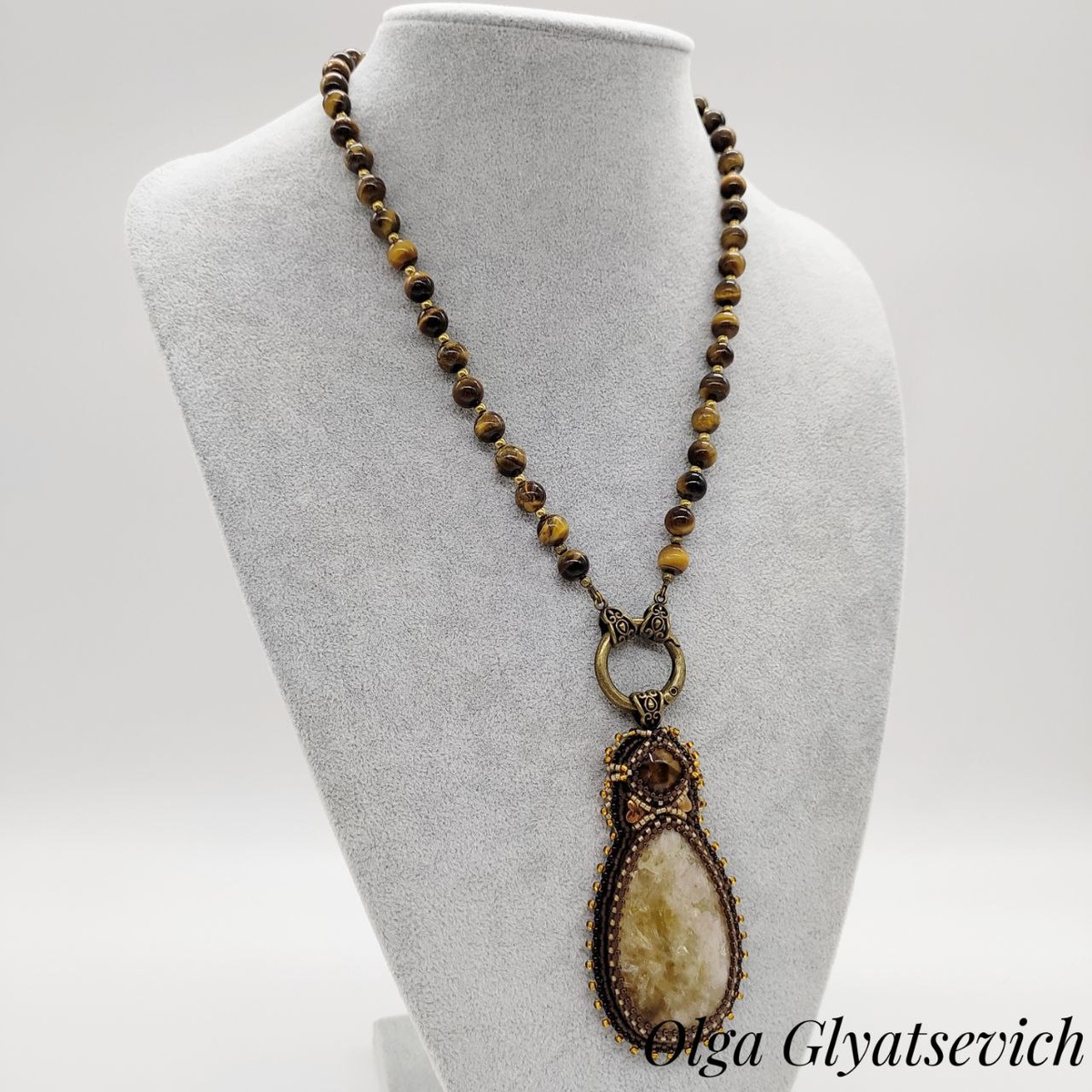 Приветствую вас, любители прекрасного! Сегодня я хочу рассказать вам об одном из моих последних творений - колье с тигровым глазом и съемным кулоном из цитрина. Но это не просто украшение, это гармоничное сочетание двух удивительных камней, каждый из которых обладает своей уникальной энергетикой.
Тигровый глаз – камень силы и уверенности. Он помогает обрести внутреннюю гармонию, защищает от негативной энергии и привлекает удачу. Считается, что тигровый глаз помогает принимать взвешенные решения и преодолевать трудности.
Цитрин, в свою очередь, известен как камень процветания и изобилия. Он дарит радость, оптимизм и уверенность в себе. Считается, что цитрин помогает привлекать деньги и успех в делах.
В этом колье я соединила эти два камня, чтобы создать украшение, которое будет не только красивым, но и полезным для своей владелицы. Кулон из цитрина оплетен японским бисером и имеет изнанку из натуральной кожи, что делает его еще более приятным на ощупь.
Материалы:
*  Тигровый глаз
*  Цитрин
*  Японский бисер
*  Натуральная кожа
Если вам понравилось это украшение и вы хотите узнать о нем больше, пишите в комментариях. А какие камни любите вы?