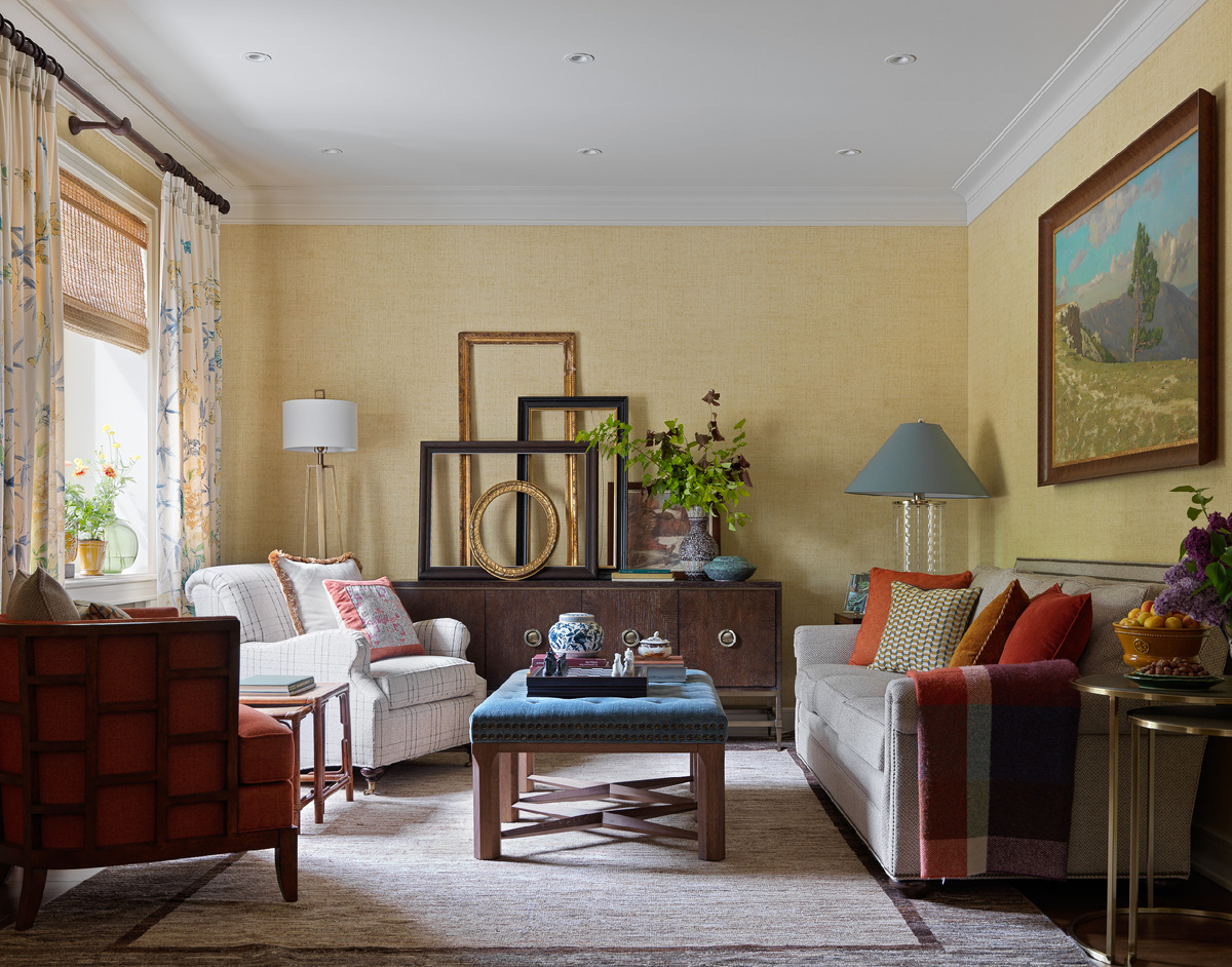 Диван Vanguard, круглые столики Universal Furniture, по центру сделанный на заказ пуф, комод Bernhardt, кресло Lexington в ткани Kravet, белое кресло Theodore Alexander, торшер Wildwood, настольная лампа Hudson Valley. Шторы из ткани Jim Thompson, обои Thibaut.