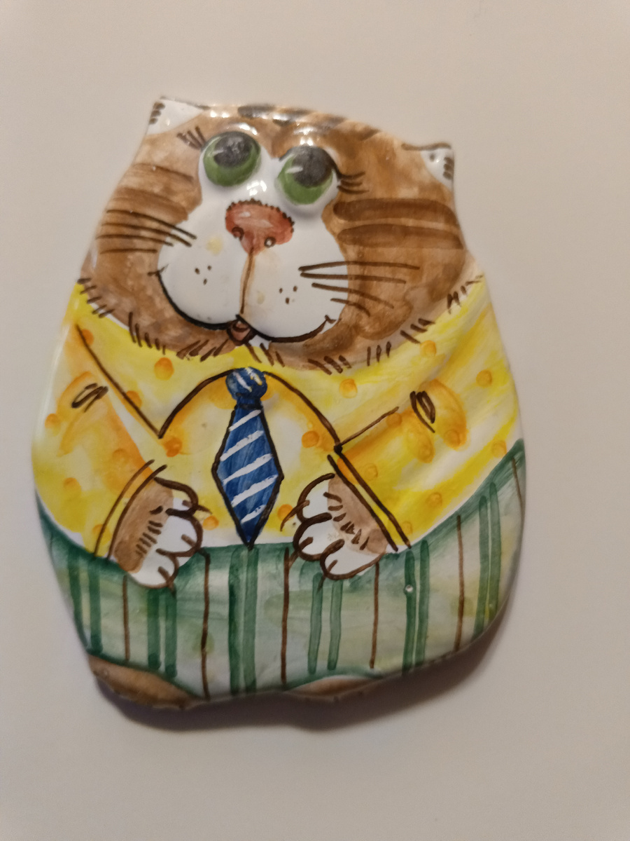 Магнит "Кот-босс". Это Ярославская майолика, ручная работа. Мы привезли его из круиза, когда была стоянка в Ярославле. Теперь он живет у нас на плите.