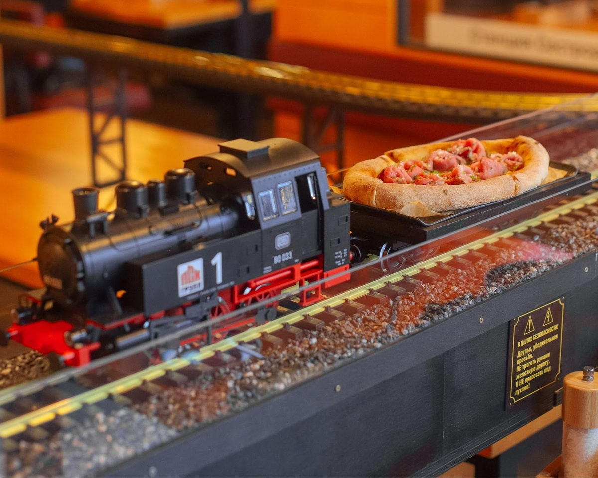 Паровозик доставляет пиццу на столе