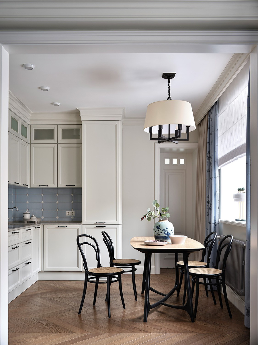 Обеденная группа, состоящая из стола со скруглёнными углами и традиционных венских стульев, — классика на все времена. Интерьер квартиры на Кропоткинской, дизайнер Елена Маркина