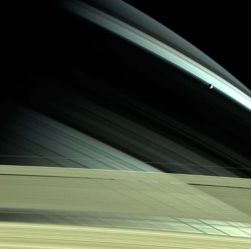 Спутник Сатурна Мимас сквозь кольца планеты. Фото НАСА