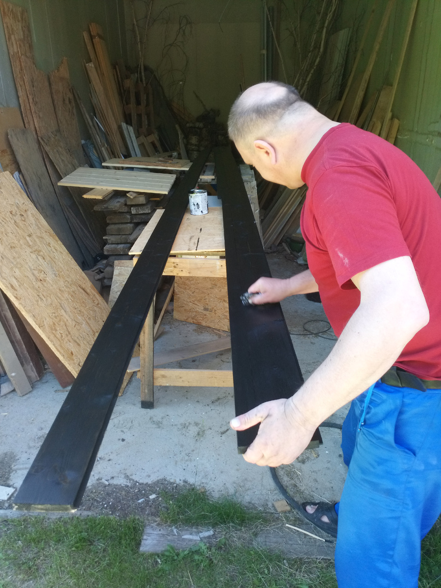 Муж покрывает маслом доску с уже выбранными пазами