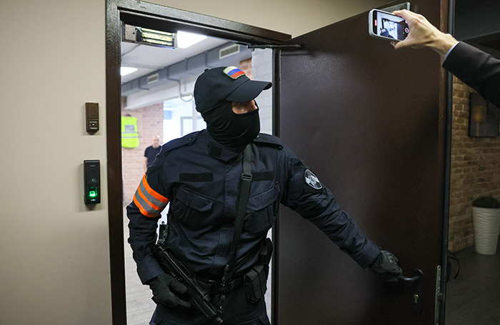    Сотрудник правоохранительных органов выходит из редакции телеграм-канала Baza, где проводились следственные мероприятия.Сергей Савостьянов/ТАСС