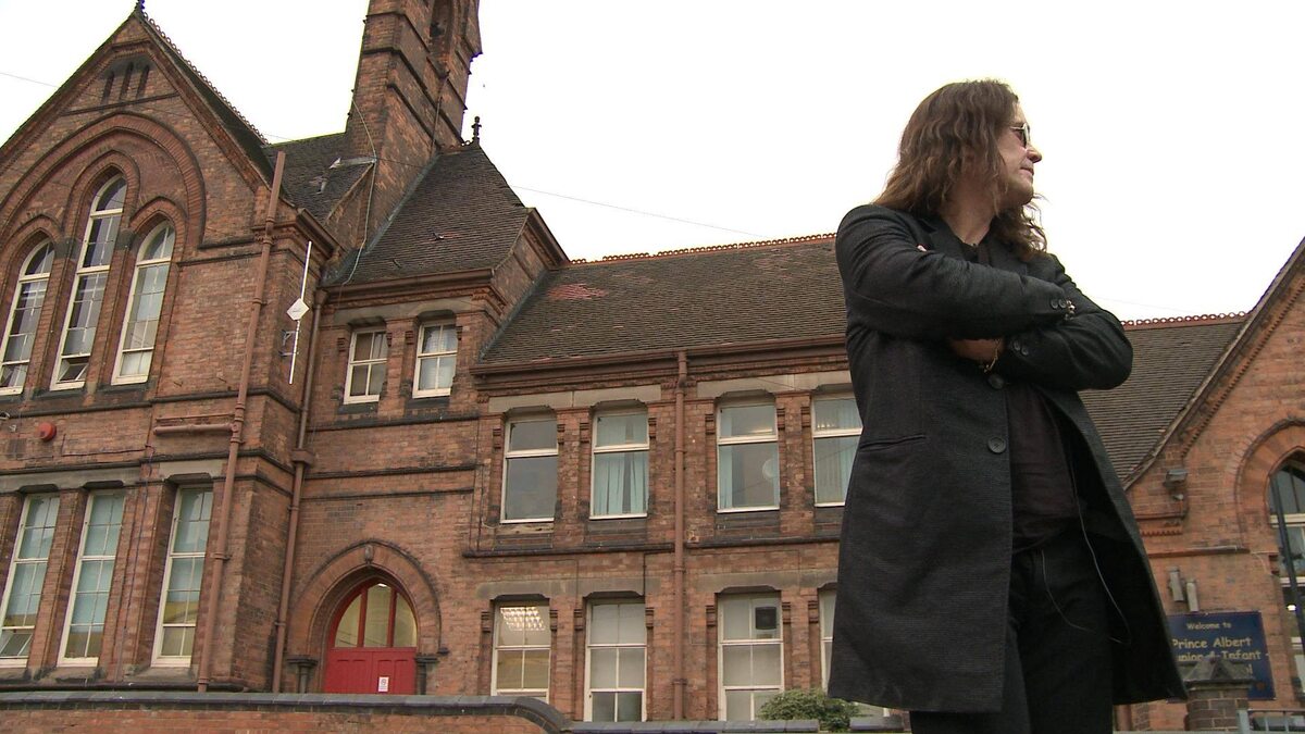 Оззи у здания своей школы в Бирмингеме.