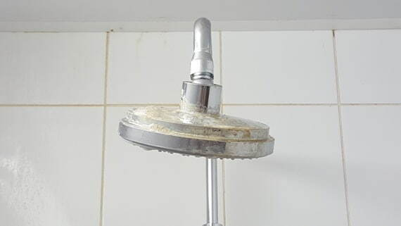 Минеральные отложения на хромированной поверхности лейки душа 