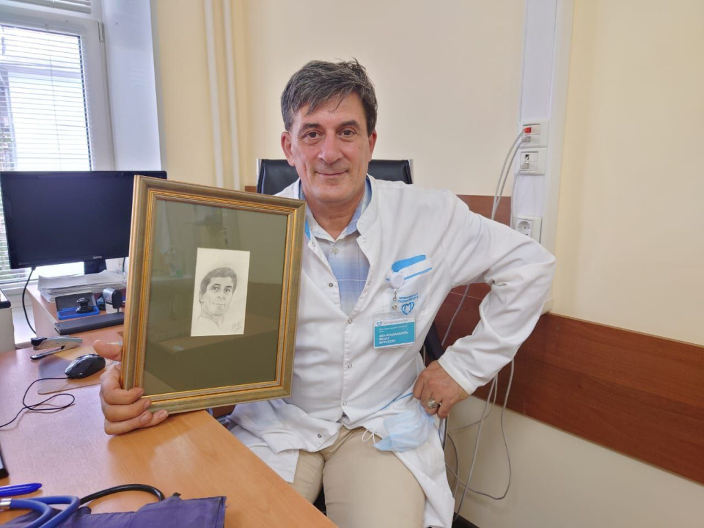 Мудар Мухъедин со своим портретом, который ему подарила пациентка в знак благодарности