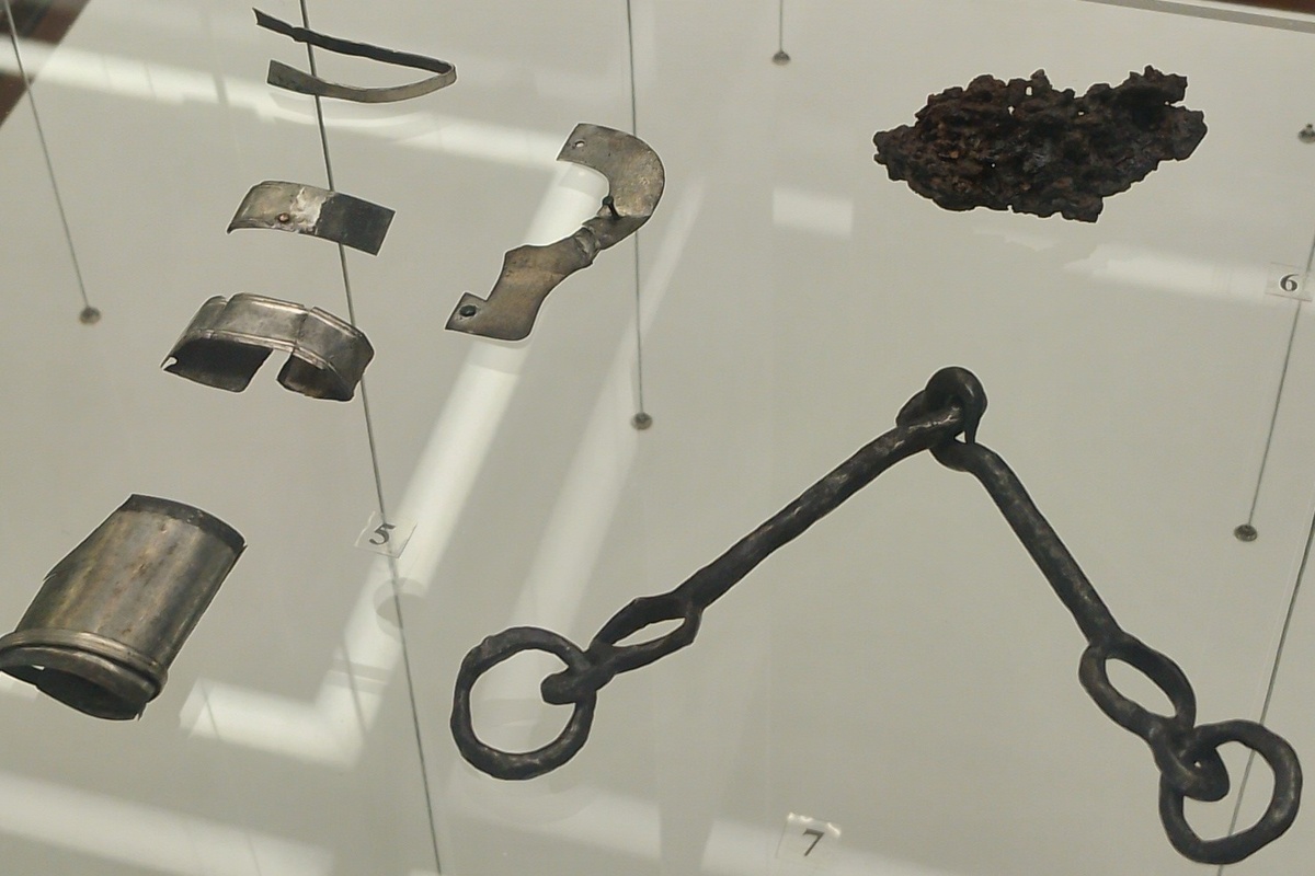 Вещи из погребения в витрине нашего музея: 5 - серебряные детали ножен меча; 6 - фрагмент железной кольчуги; 7 - железные удила