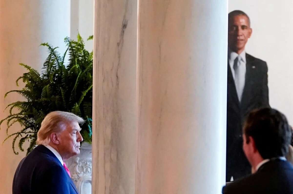    Президент США Дональд Трамп на фоне портрета бывшего президента США Барака Обамы в Белом доме в Вашингтоне.