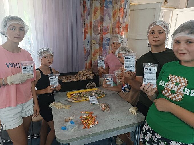 Девочки участницы мастер-класса держат в руках пакеты с сухим супом Борщ