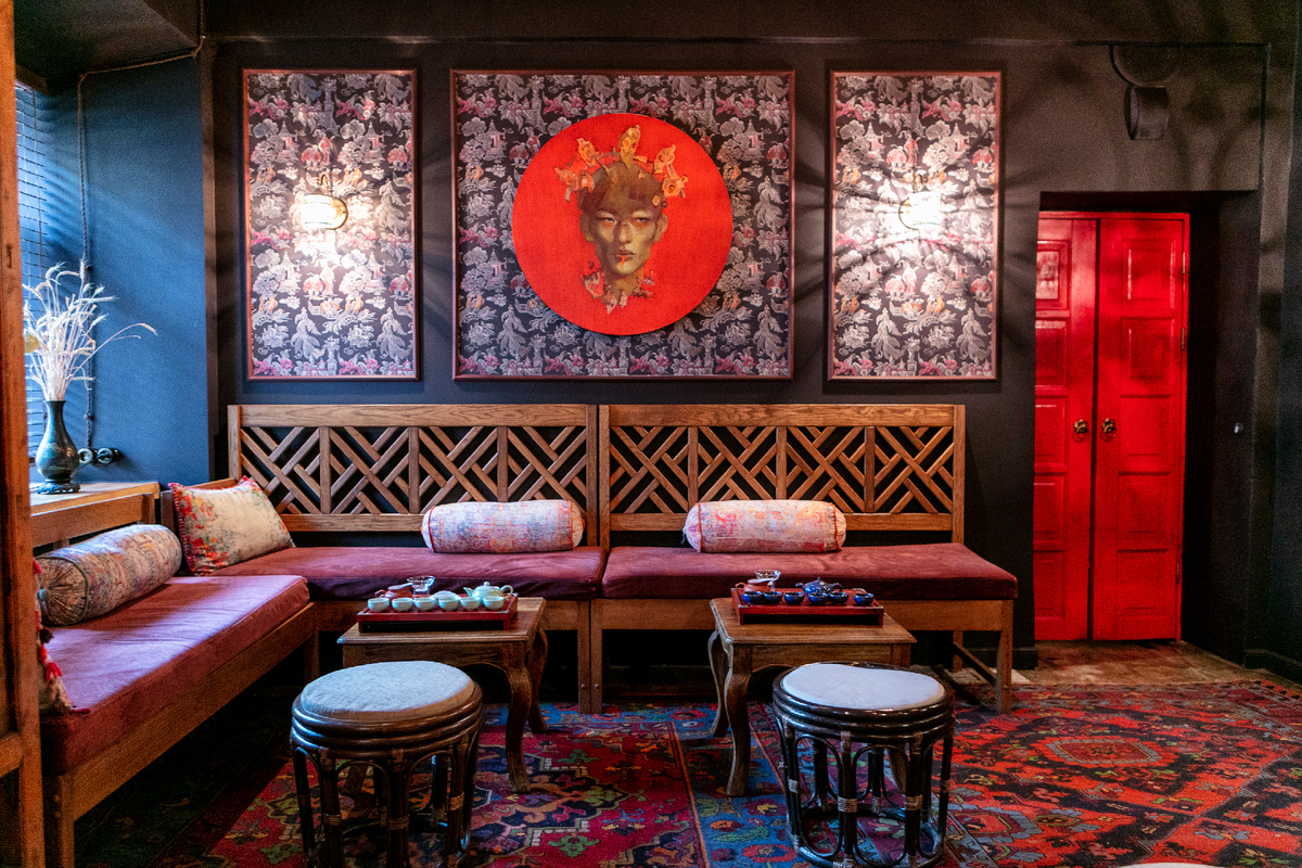 Декоративные элементы играют ключевую роль в создании аутентичной атмосферы. Красные фонари, шёлковые драпировки, антикварные вазы и статуэтки создают неповторимый восточный колорит.
Мебельное оформление включает в себя низкие столики, мягкие диваны с высокими спинками и подушками с вышивкой.Всё это создаёт атмосферу расслабленности и комфорта. Освещение играет особую роль — приглушённый свет, создаваемый с помощью бра,и китайских фонариков, создаёт интимную атмосферу.
Акустическое оформление не менее важно. Звуки традиционной китайской,корейской и японской музыки, доносящиеся из скрытых динамиков, усиливают погружение в атмосферу древнего Китая. Стены украшены традиционными картинами.
