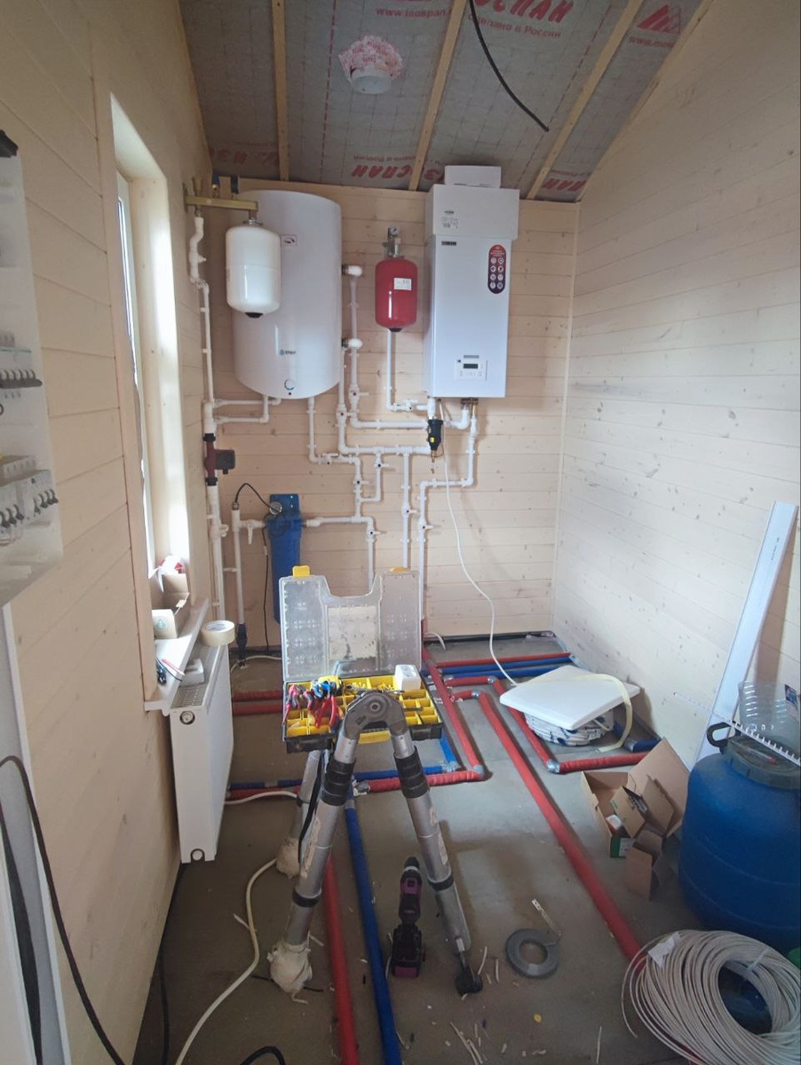 Узел отопления и водоснабжения: бойлер, котёл, фильтрация и разводка по дому. Вся система аккуратно собрана в одном техническом помещении. Фото с объекта «Интел Групп».