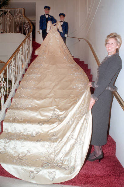 Дизайнер Линдка Сирах стоит на лестнице отеля Ritz, держа шлейф свадебного платья герцогини Йоркской Сары Фергюсон. Ей помогают Абрахам Ассаф и Кевин Каллахан из отеля Ritz. Фото 
MediaNews Group/Boston Herald via Getty Images