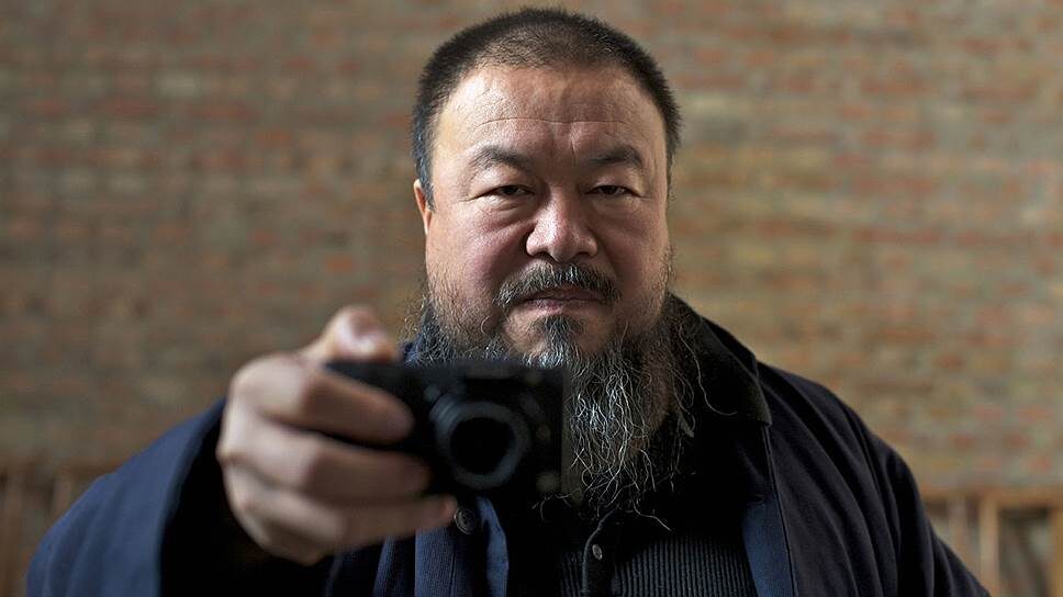 Те три китайца чем-то напомнили мне китайского диссидента, художника, архитектора по имени Ай Вэйвэй. На этом фото - именно он. Фото с сайта https://www.kommersant.ru/ 