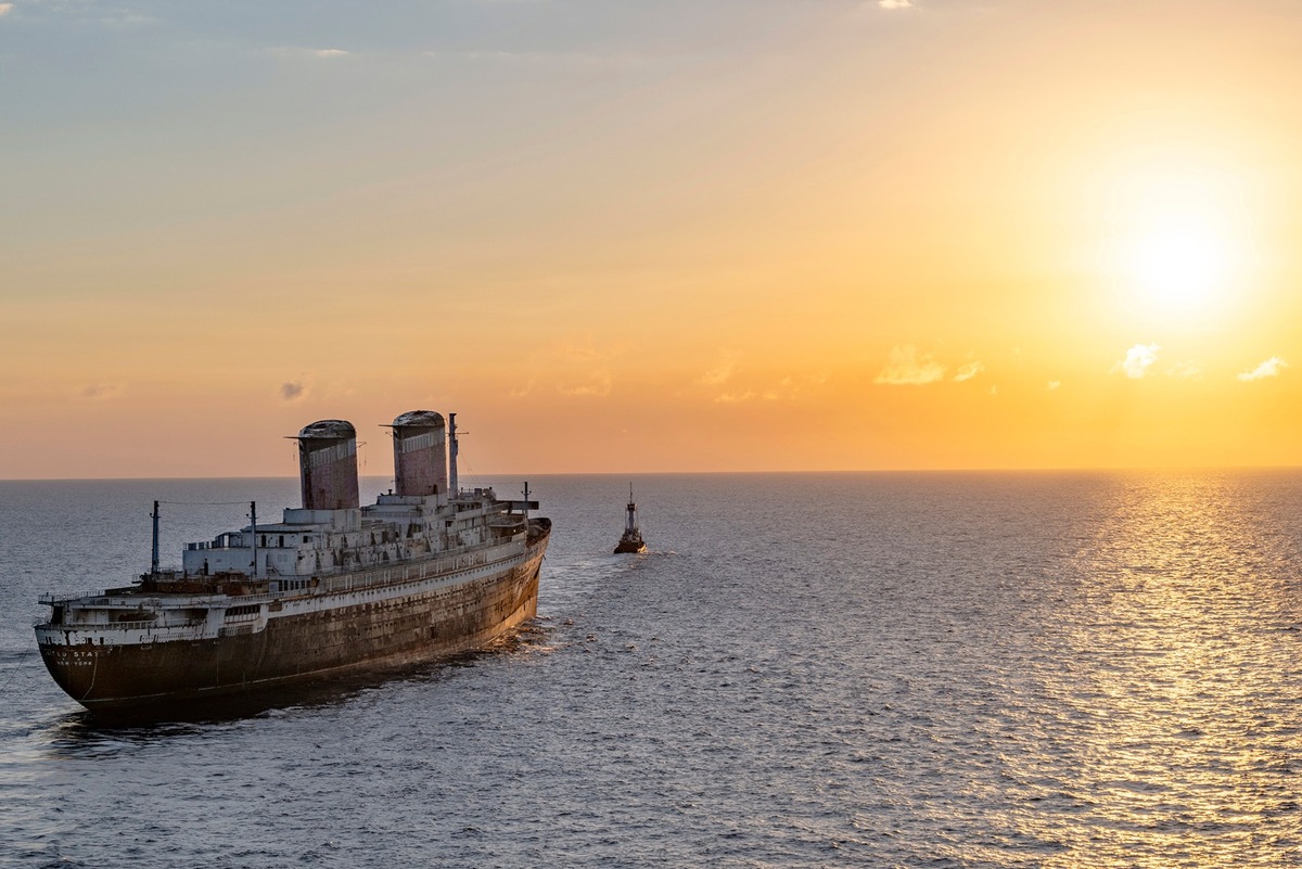 Сухогруз SS United States буксируют на закате мимо Ки-Уэста, штат Флорида, в сторону Мобила, штат Алабама, в четверг, 27 февраля 2025 года, где его подготовят к использованию в качестве искусственного рифа у побережья Мексиканского залива во Флориде.