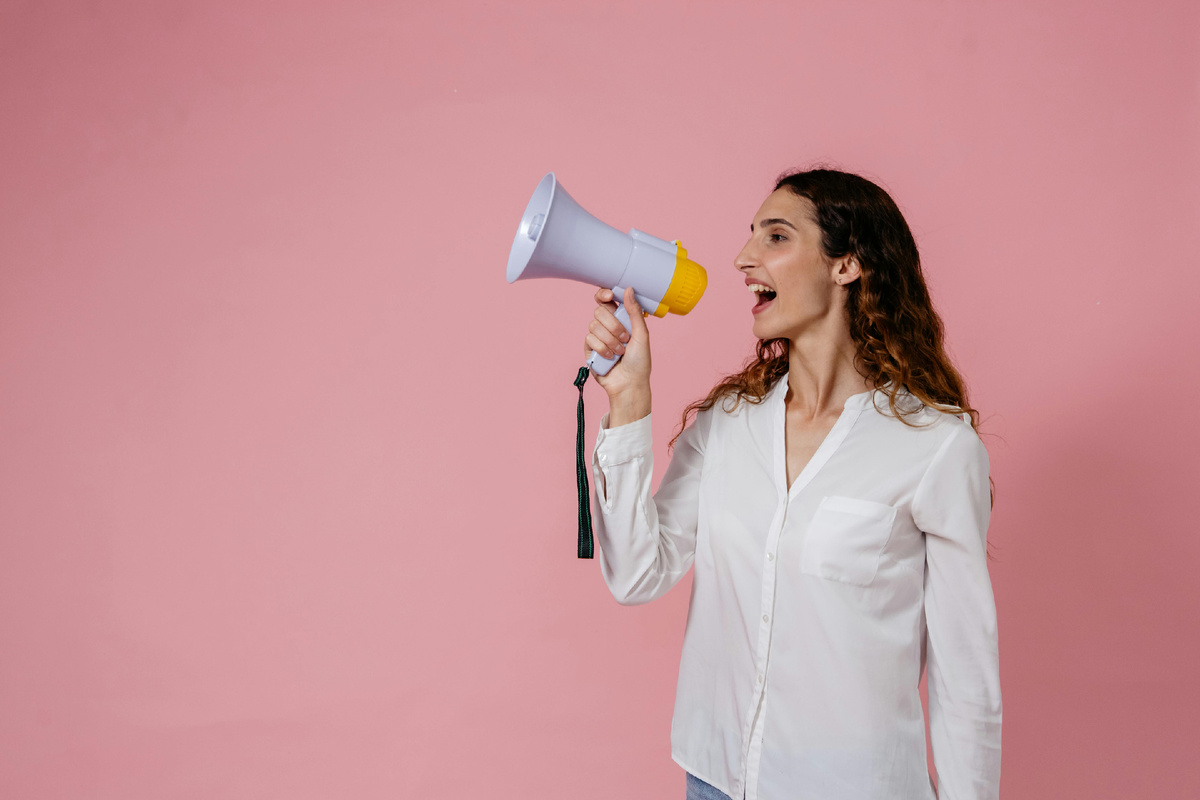 Photo by Pavel Danilyuk: https://www.pexels.com/photo/woman-in-white-button-up-long-sleeve-shirt-using-a-megaphone-8638302/