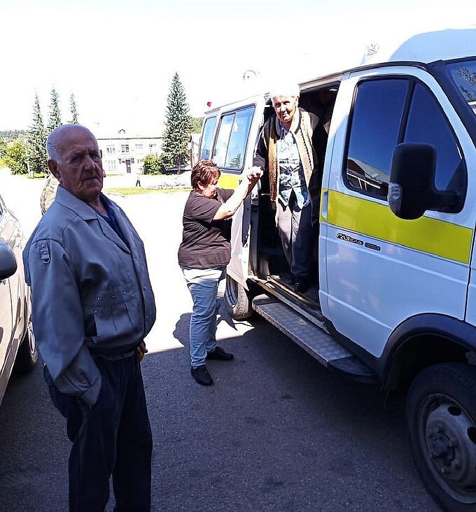 Пожилая женщина выходит из автомобиля мобильной бригады