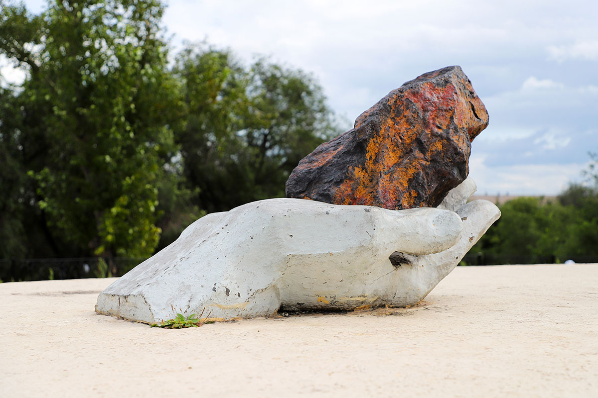 Ладонь, которая держит обломок железной руды