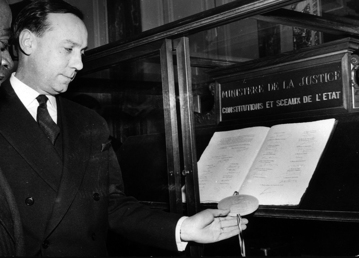 Мишель Дебре ставит государственную печать на оригинальном экземпляре Конституции. © AFP