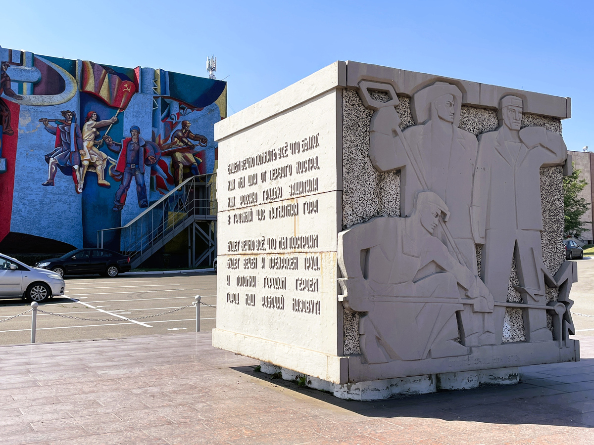 Памятный знак расположен у живописного панно "Славим человека труда"