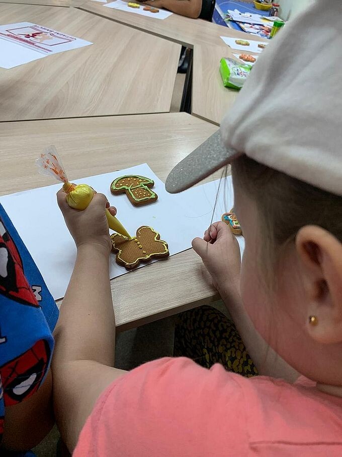 Девочка выдавливает глазурь из мешка на пряник