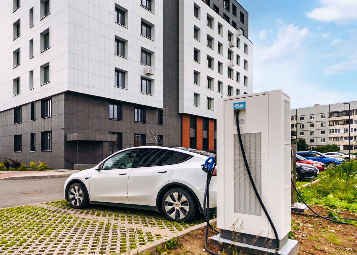 Эко-парковка вынесена за пределы дома. Такое решение безопасно для жителей дома, особенно для детей. На парковке находится пара зарядных станций для электромобилей.