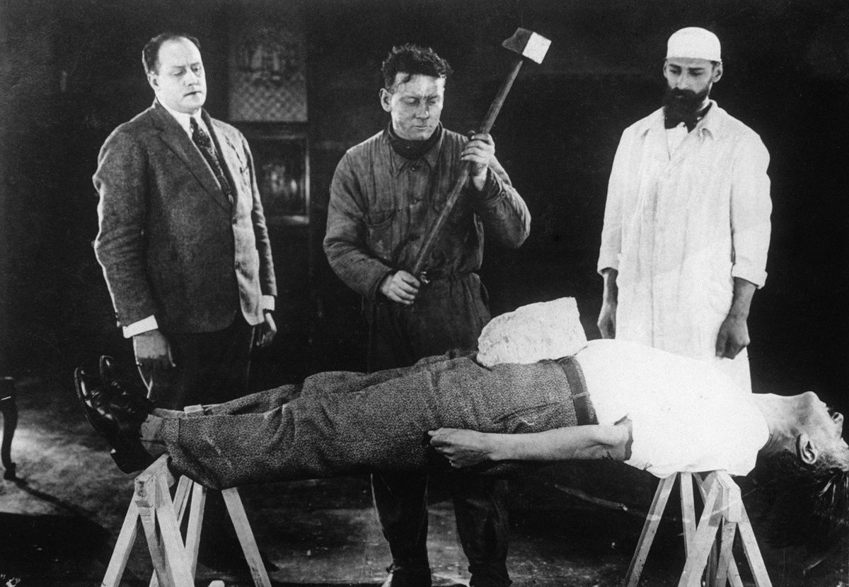    Театральная постановка с человеком, подвергающимся гипнозу с камнем на животе