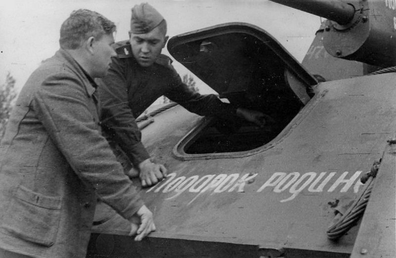 Старший сержант Александр Николаевич Панкратов (1924 г.р.) - механик-водитель 1892-го самоходного артиллерийского полка показывает отцу Николаю Петровичу Панкратову, главному механику харьковского строительно-монтажного треста № 4, устройство самоходной артиллерийской установки СУ-76М с собственным именем «Подарок Родине», построенную на отцовские средства. 