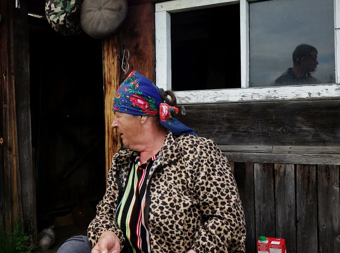 Женщина и её сын отражаются в стекле.