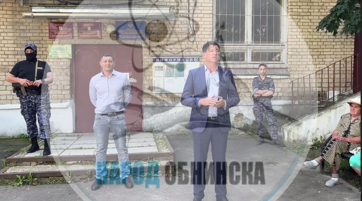 глава деревни Кривское Эльдар Абасов (в джинсах) и представитель района (в костюме) встретились с жителям, Абасова охраняет автоматчик. Многие СМИ отрезали с кадра автоматчика, чтобы не шокировать население / телеграм-канал "ЧП Боровский район"
