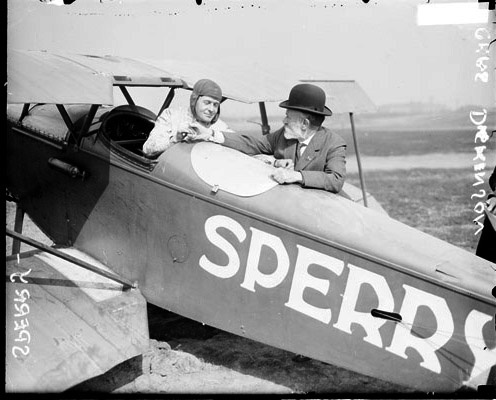 Летчик-изобретатель Лоуренс Сперри сидит в самолете и общается с Чарльзом Дикинсоном. Источник: commons.wikimedia.org