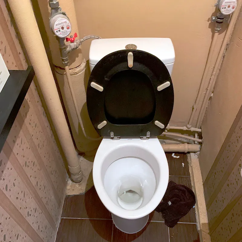 Отверстие находится ближе к краю унитаза и под наклоном