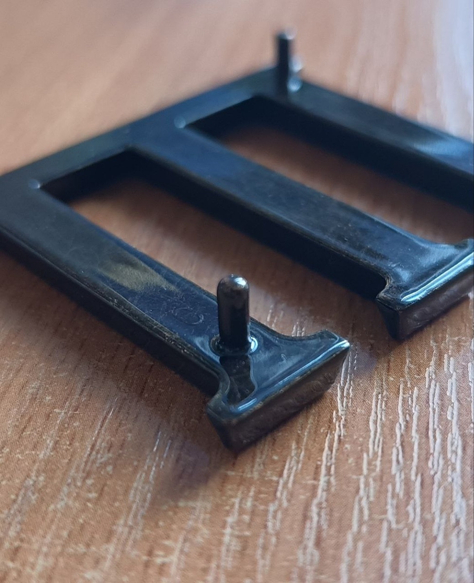 Буква из бронзы, штырёк крупным планом и фирменный логотип литера С.