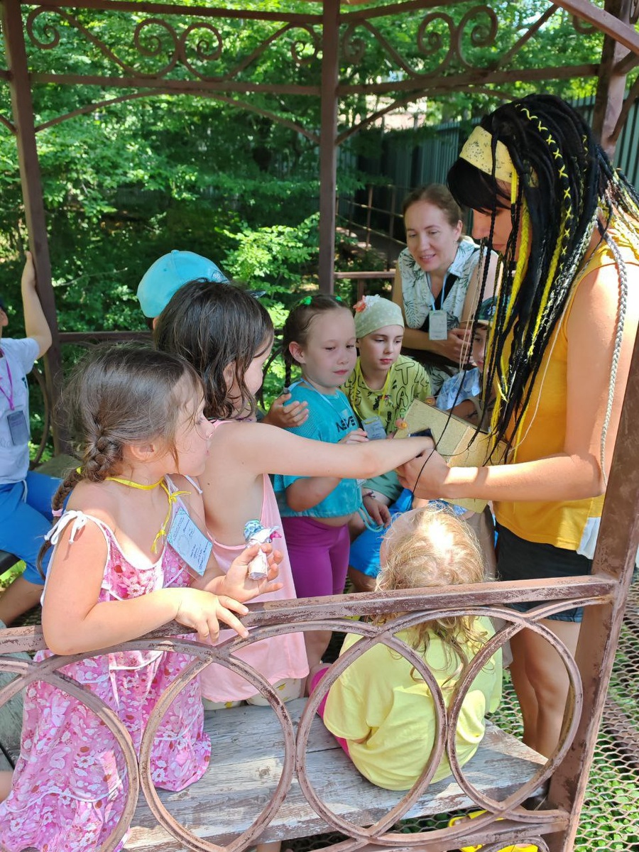 Дети, играющие в лагере, ищут подсказку в волшебной коробке доброй волшебницы Виллины