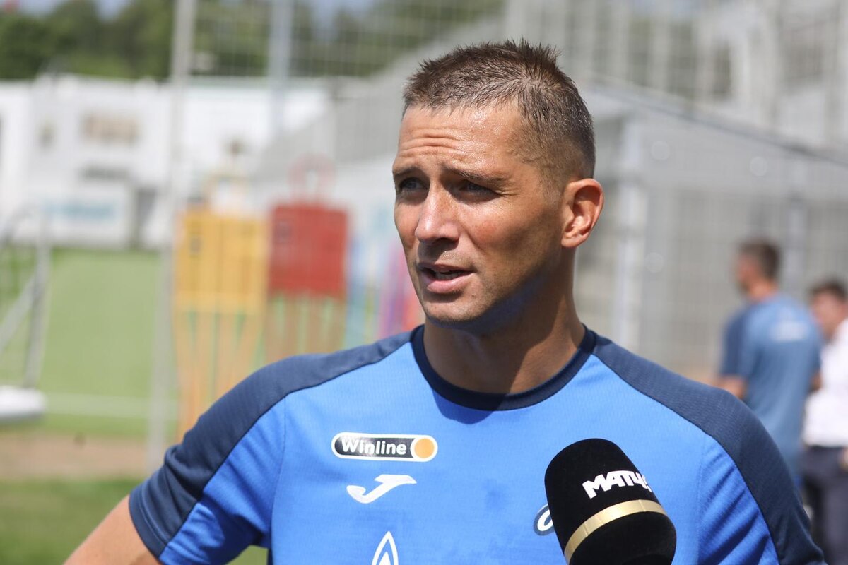 Sportsman in a blue FC Zenit training jersey being interviewed on a football training ground vecherka-spb