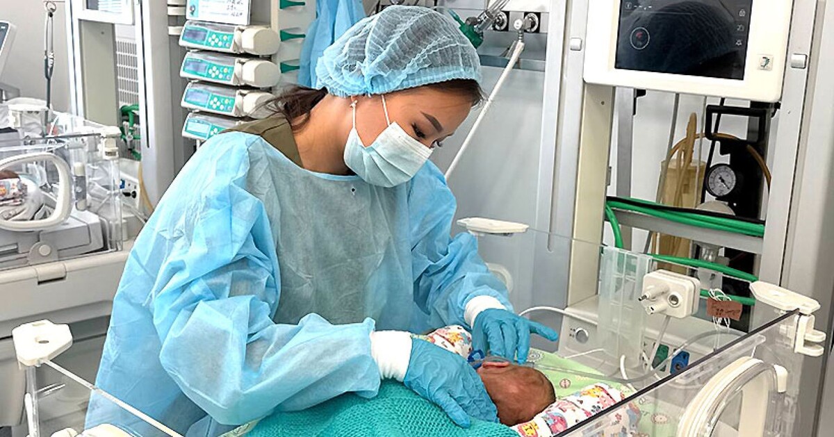 Младшая медсестра следит за жизненно важными показателями младенца.