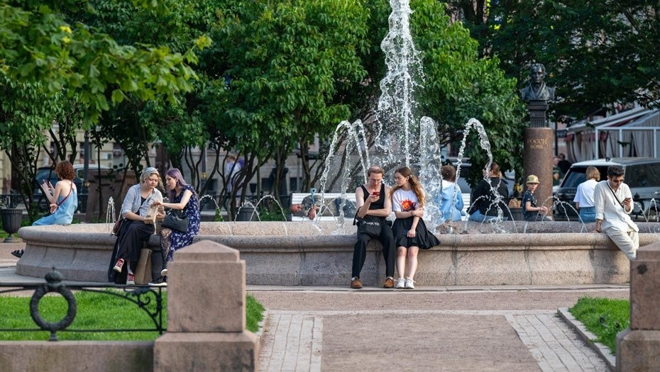    Манежная площадь. Фонтан в Ново-Манежном сквере на Манежной площади, расположен по адресу: Манежная площадь, д. 4, Люди отдыхают, сидя на стенках. фонтана. Автор фото: Тихонов Михаил