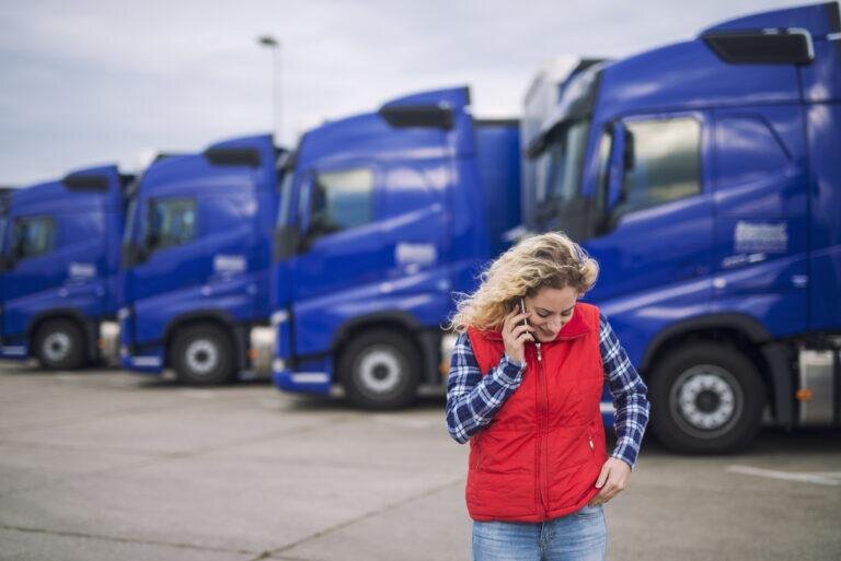   Female trucker talking on the phone about shipment that has to be delivered. Артем Силантьев