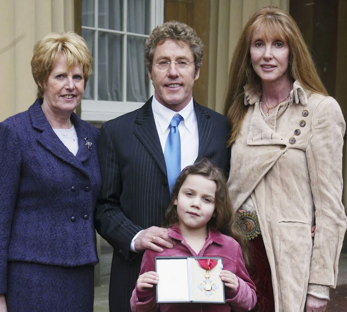 Роджер Долтри с семьёй в Букингемском дворце после получения ордена CBE.
Долтри получает CBE в 2005 году с сестрой, внучкой Лили и женой Хизер. Фото: Тим Кларк/ROYAL ROTA/GETTY IMAGES