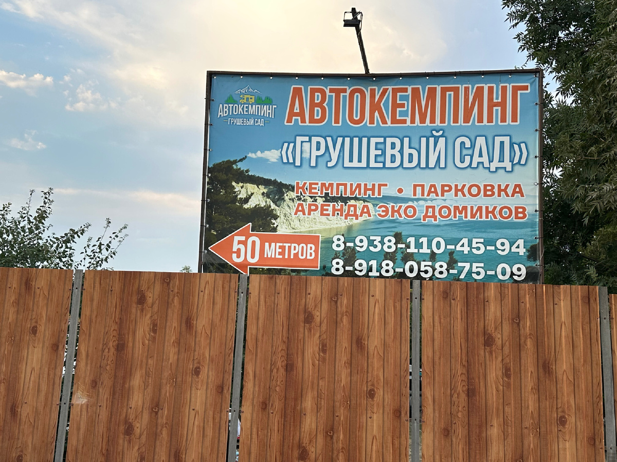 Автокемпинг огорожен забором.